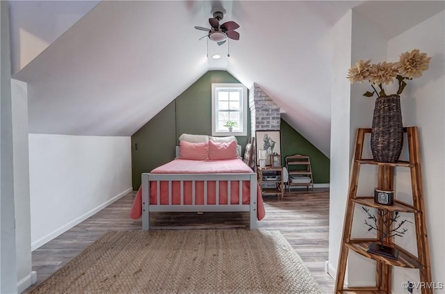 bedroom with baseboards, vaulted ceiling, wood finished floors, and a ceiling fan