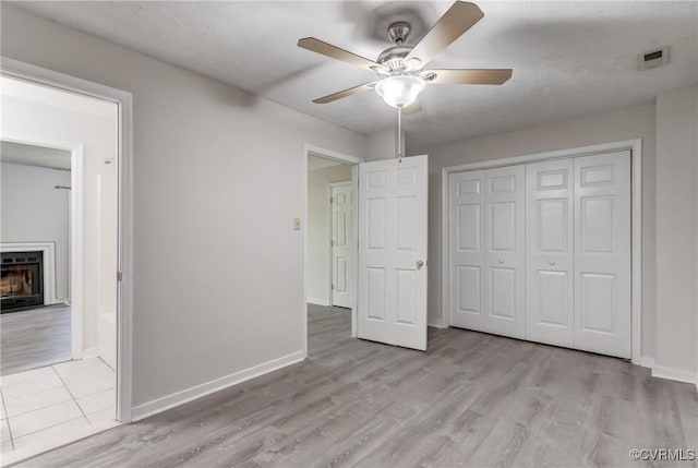 12255 Shore View Dr, Henrico, VA 23233 - unfurnished bedroom with wood finished floors, a fireplace, a closet, and a ceiling fan