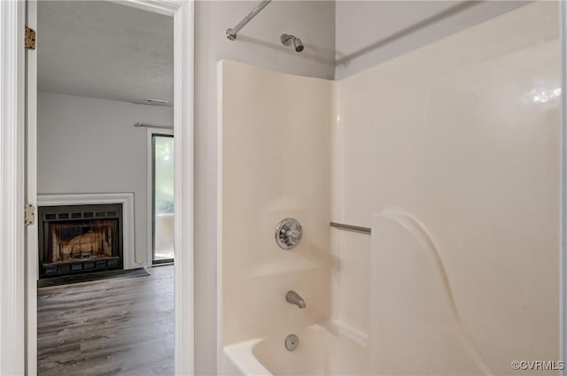 12255 Shore View Dr, Henrico, VA 23233 - bathroom featuring shower / bathtub combination, a fireplace, and wood finished floors