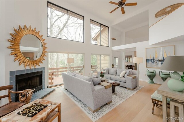 941 Wilton Coves Dr, Hartfield, VA 23071 - living room featuring ceiling fan, wood finished floors, a tiled fireplace, and high vaulted ceiling