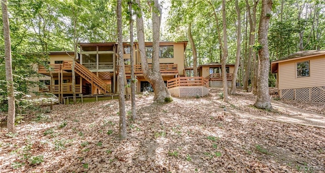 941 Wilton Coves Dr, Hartfield, VA 23071 - back of property featuring a sunroom, stairs, and a wooden deck