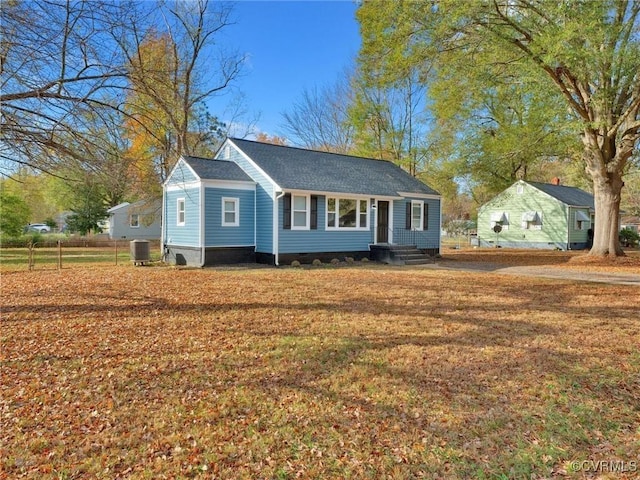 view of front of house with central AC unit, crawl space, and a front lawn