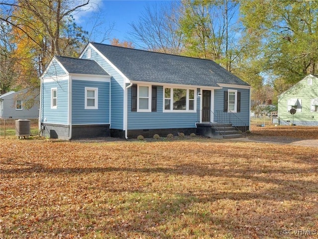 view of front of home featuring central air condition unit, crawl space, a front yard, and a shingled roof
