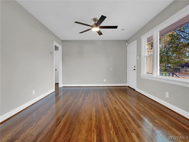 unfurnished room featuring dark wood-style floors, baseboards, and ceiling fan