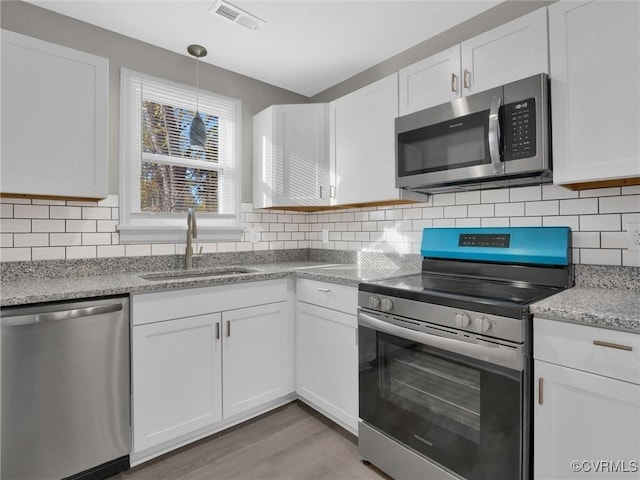 kitchen featuring visible vents, white cabinetry, a sink, and appliances with stainless steel finishes