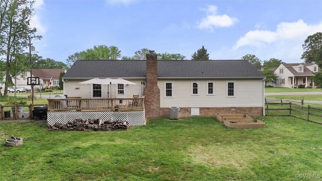 back of house with fence, a vegetable garden, a deck, a chimney, and a yard