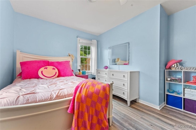 bedroom with baseboards and wood finished floors