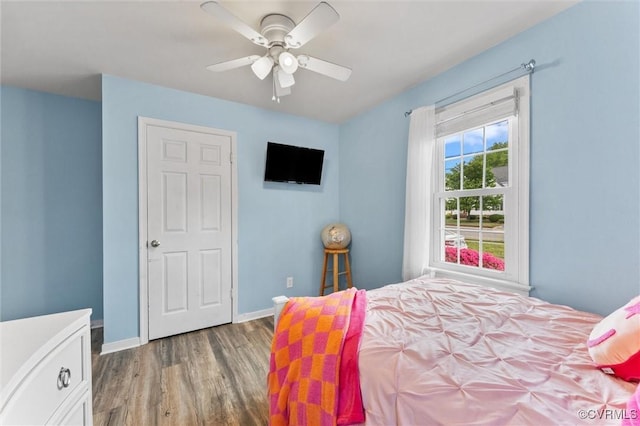 bedroom featuring baseboards, a ceiling fan, and wood finished floors