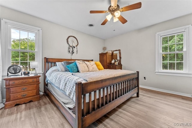 bedroom featuring baseboards, visible vents, ceiling fan, and light wood-type flooring
