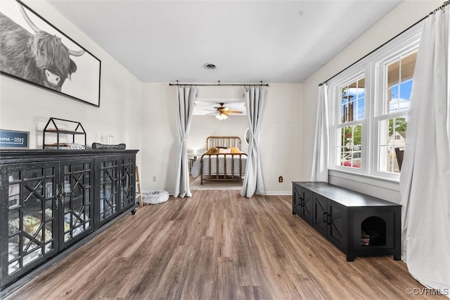 interior space with baseboards, ceiling fan, and wood finished floors