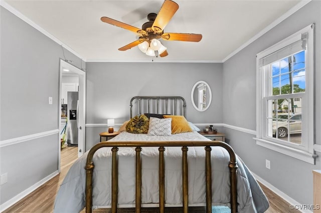 bedroom featuring baseboards, ornamental molding, stainless steel fridge, and wood finished floors