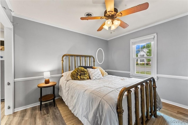 bedroom with baseboards, ornamental molding, ceiling fan, and wood finished floors