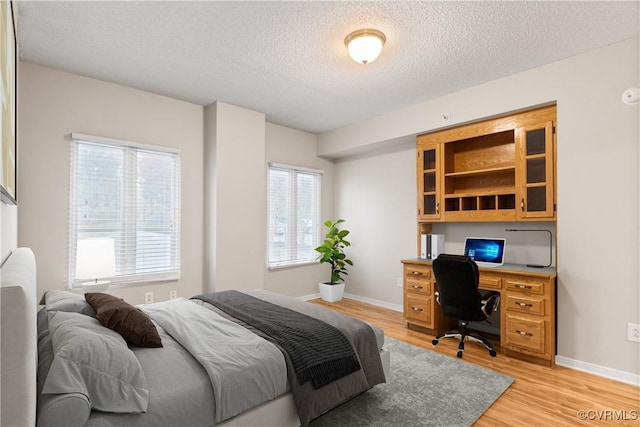 301 Beacon Ridge Dr Unit 109, Hopewell, VA 23860 - bedroom featuring a textured ceiling, light wood-style floors, and an office area