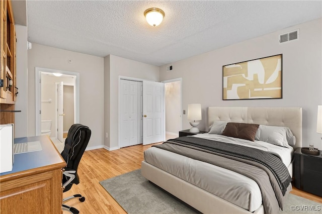 301 Beacon Ridge Dr Unit 109, Hopewell, VA 23860 - bedroom with a textured ceiling, light wood-style floors, a closet, an office area, and connected bathroom