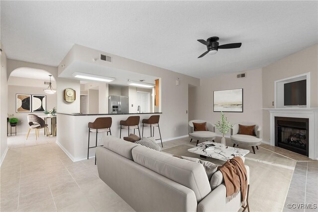 301 Beacon Ridge Dr Unit 109, Hopewell, VA 23860 - living area with light tile patterned floors, a ceiling fan, a fireplace with raised hearth, and arched walkways