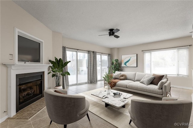 301 Beacon Ridge Dr Unit 109, Hopewell, VA 23860 - living room featuring ceiling fan, a fireplace with raised hearth, light tile patterned flooring, and a textured ceiling