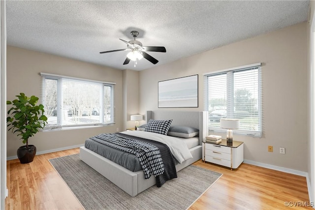 301 Beacon Ridge Dr Unit 109, Hopewell, VA 23860 - bedroom featuring multiple windows, light wood finished floors, a textured ceiling, and a ceiling fan