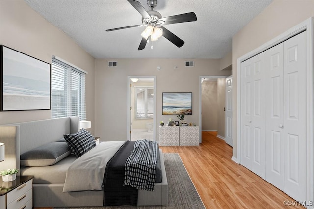 301 Beacon Ridge Dr Unit 109, Hopewell, VA 23860 - bedroom featuring light wood finished floors, a textured ceiling, a closet, ceiling fan, and ensuite bath