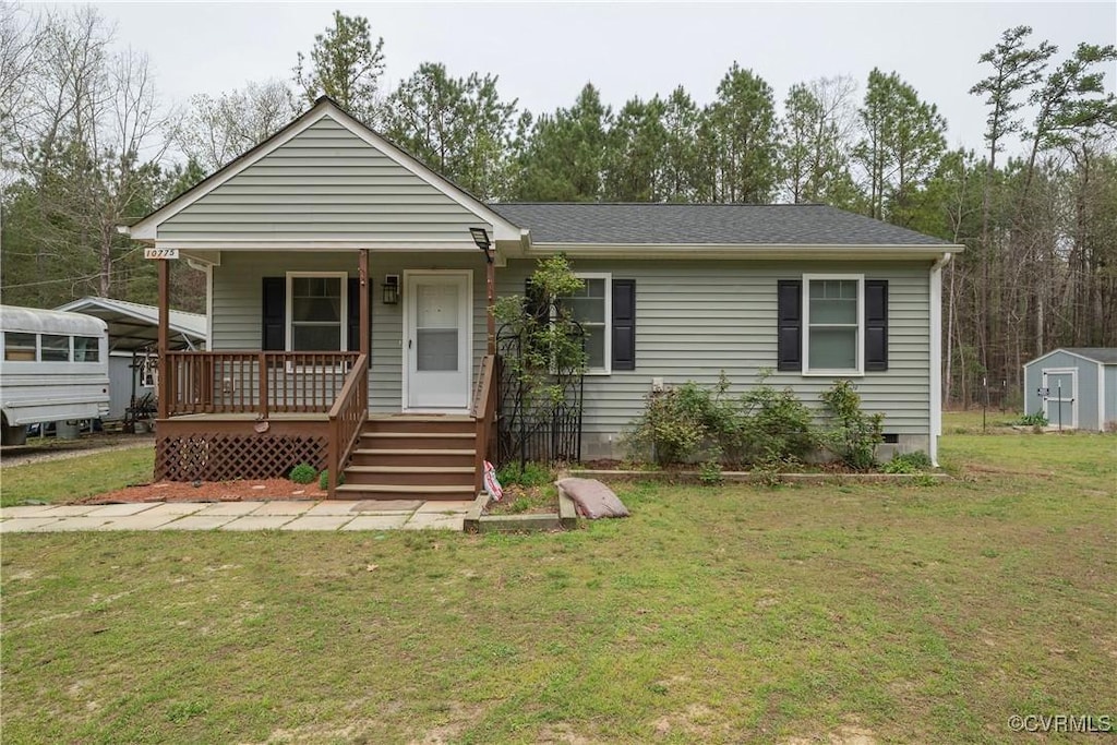 view of front facade featuring a shed, crawl space, an outdoor structure, a porch, and a front yard