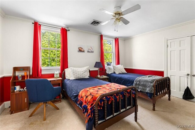 carpeted bedroom featuring ceiling fan, ornamental molding, multiple windows, and visible vents