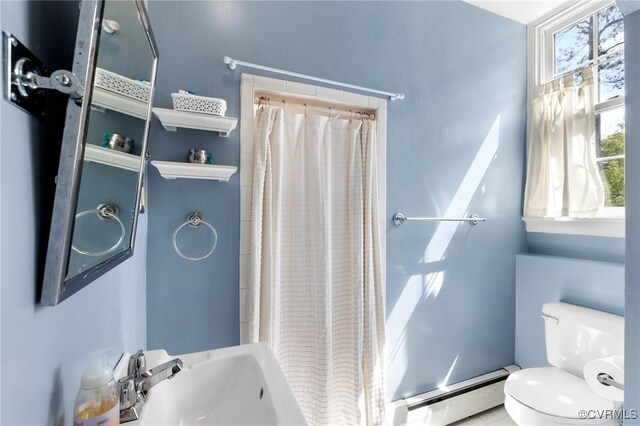 full bath with a shower with curtain, a sink, toilet, baseboard heating, and tile patterned flooring