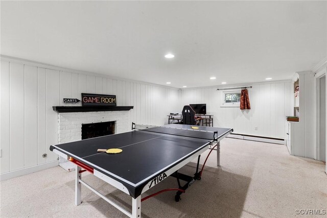 playroom with carpet floors, a fireplace, a baseboard radiator, and a decorative wall