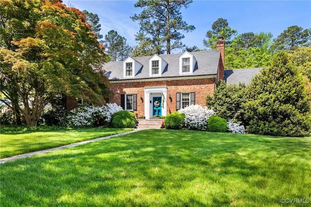 cape cod-style house featuring a front lawn, brick siding, and a chimney