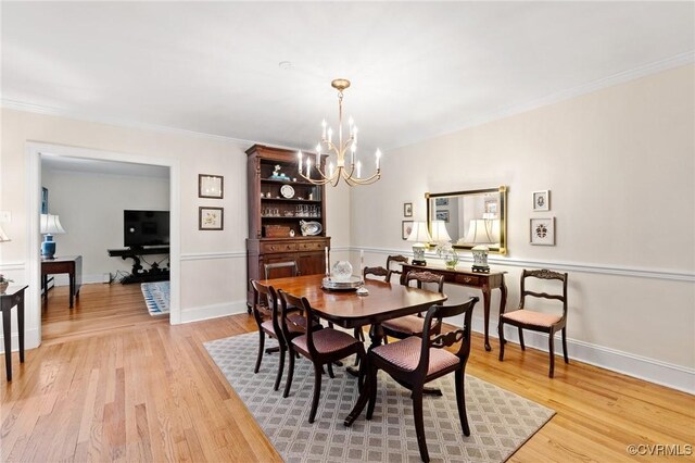 dining space featuring an inviting chandelier, light wood finished floors, and baseboards