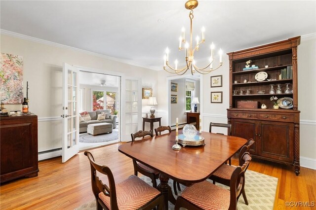 dining area with an inviting chandelier, ornamental molding, french doors, a baseboard heating unit, and light wood-style floors