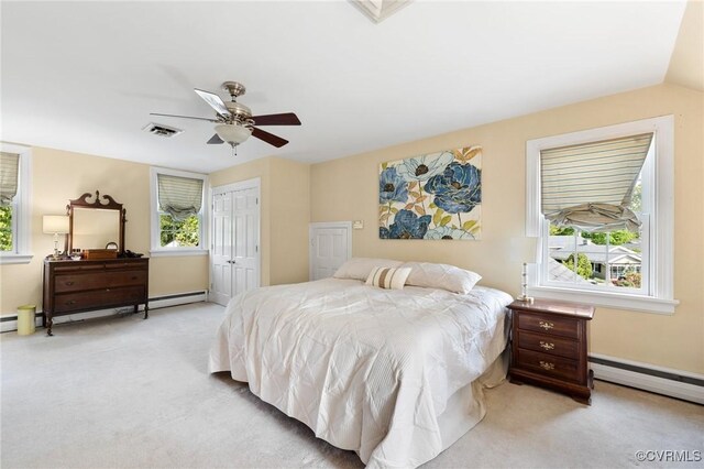 bedroom featuring a baseboard radiator, a closet, visible vents, and light carpet