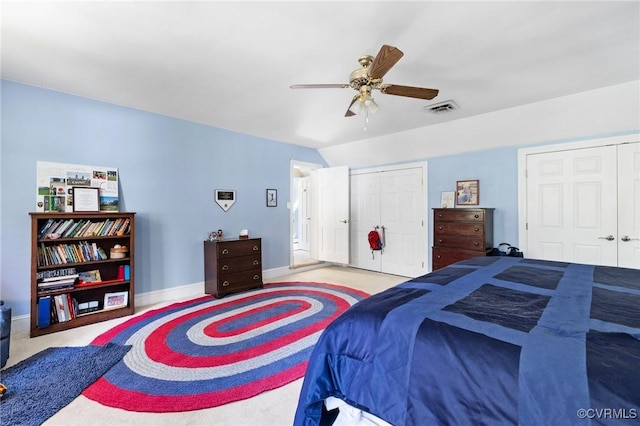 carpeted bedroom with baseboards, a ceiling fan, multiple closets, and visible vents