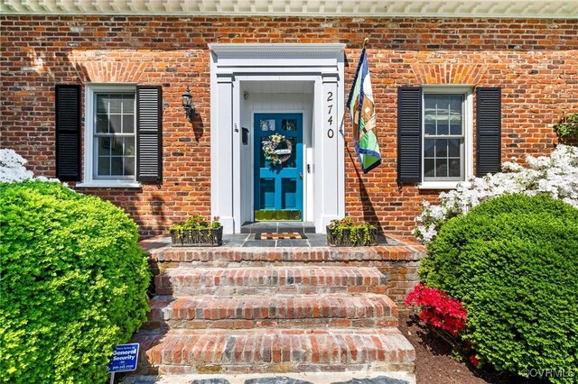 entrance to property featuring brick siding