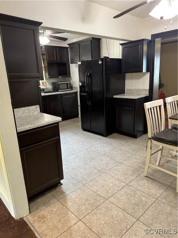 2919 Park Dr, Petersburg, VA 23805 - kitchen with a ceiling fan, black refrigerator with ice dispenser, stainless steel microwave, light countertops, and light tile patterned floors