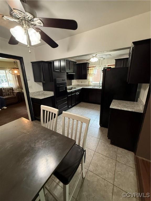 2919 Park Dr, Petersburg, VA 23805 - kitchen featuring dark cabinets, black appliances, a ceiling fan, light countertops, and light tile patterned floors