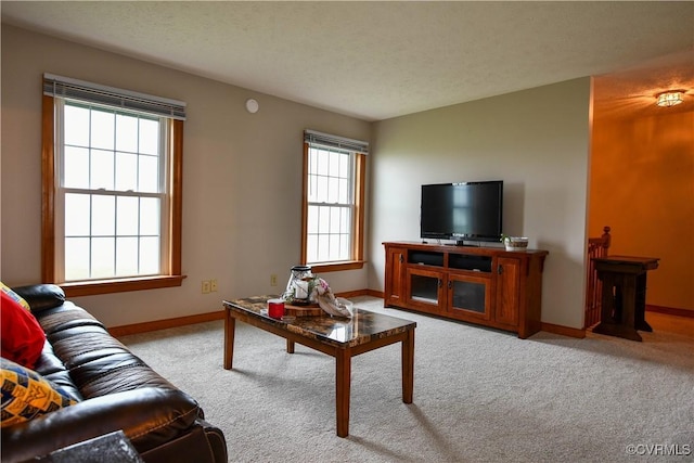 living area with baseboards, carpet flooring, and a textured ceiling
