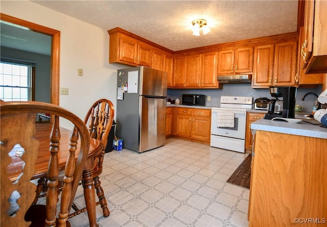 kitchen with under cabinet range hood, white range with electric cooktop, freestanding refrigerator, black microwave, and light floors