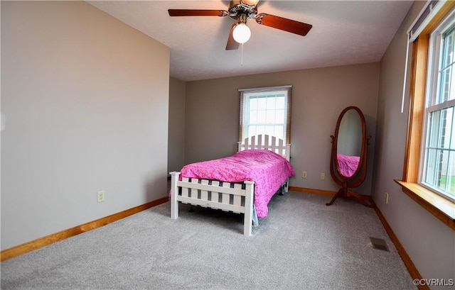 carpeted bedroom with baseboards, ceiling fan, and visible vents