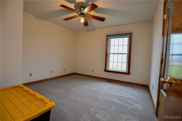 spare room with carpet flooring, baseboards, ceiling fan, and visible vents