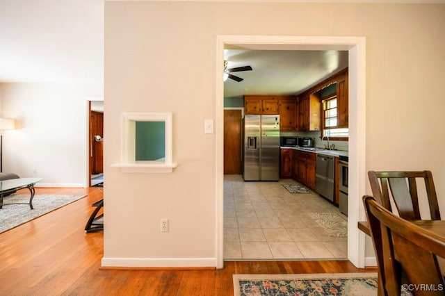 8186 Signal Hill Rd, Richmond, VA 23111 - kitchen featuring light wood-style flooring, appliances with stainless steel finishes, a sink, baseboards, and a ceiling fan