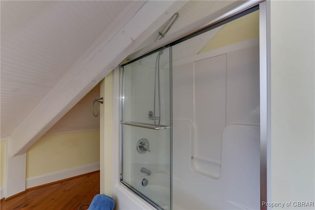 bathroom with baseboards, bath / shower combo with glass door, lofted ceiling, and wood finished floors