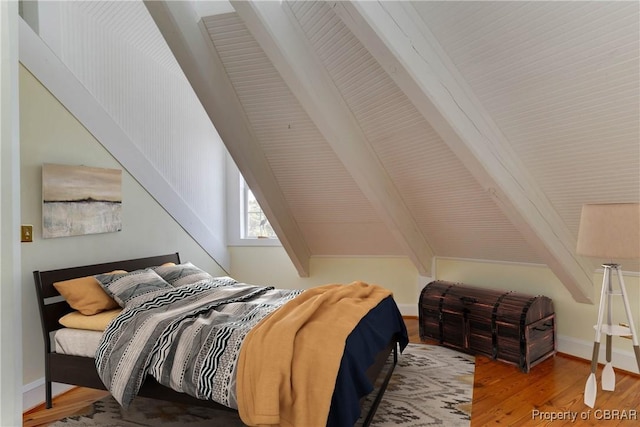 bedroom featuring lofted ceiling with beams and wood finished floors