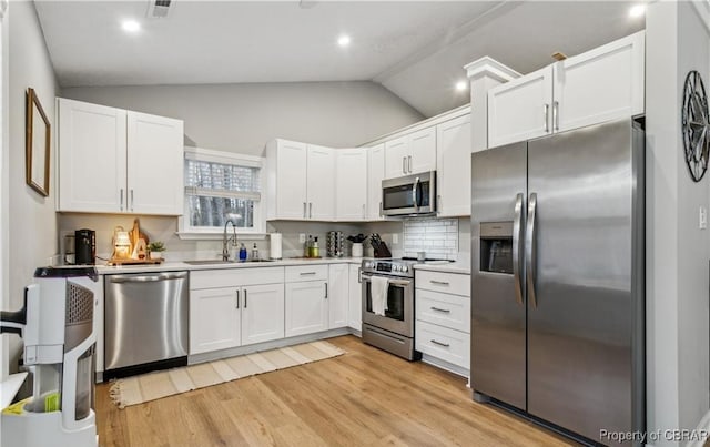104 Martin Ln, Bohannon, VA 23021 - kitchen featuring white cabinets, lofted ceiling, a sink, and appliances with stainless steel finishes