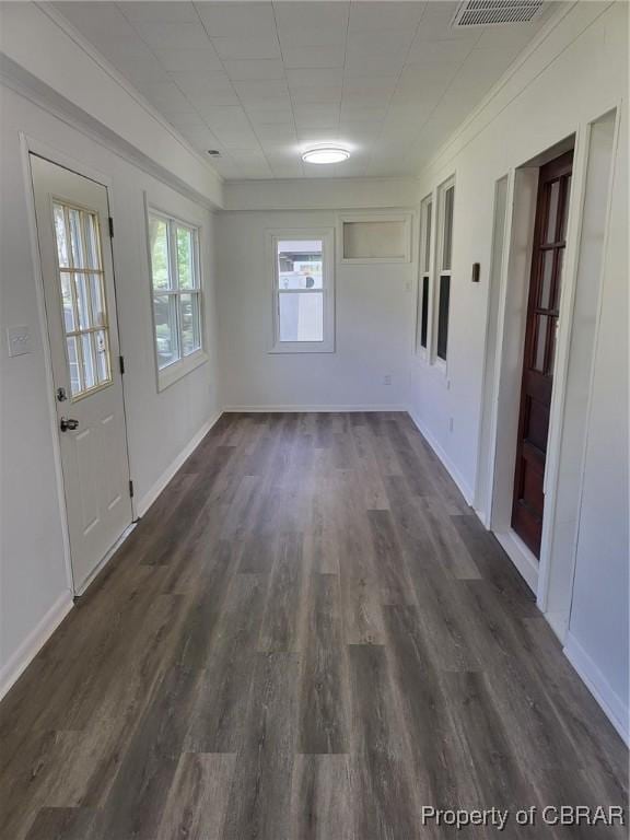 unfurnished room with dark wood-style floors, baseboards, and visible vents