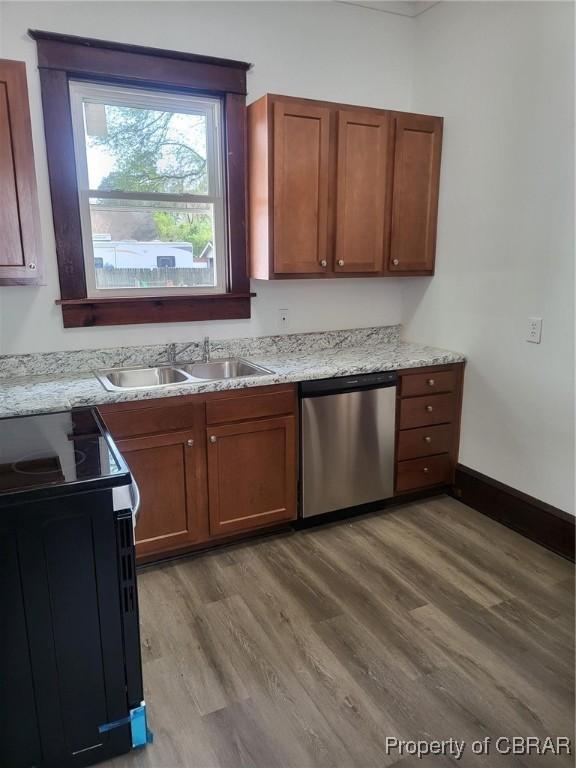 kitchen with wood finished floors, stainless steel dishwasher, a sink, and electric stove