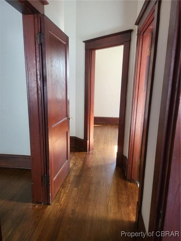 hall featuring baseboards and wood finished floors