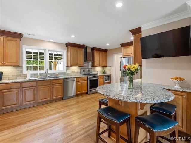 9208 Gayton Rd, Glen Allen, VA 23229 - kitchen with appliances with stainless steel finishes, wall chimney range hood, a breakfast bar, tasteful backsplash, and recessed lighting