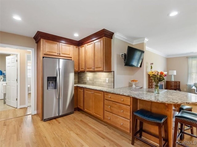 9208 Gayton Rd, Glen Allen, VA 23229 - kitchen with stainless steel fridge, a peninsula, light wood finished floors, light stone counters, and backsplash