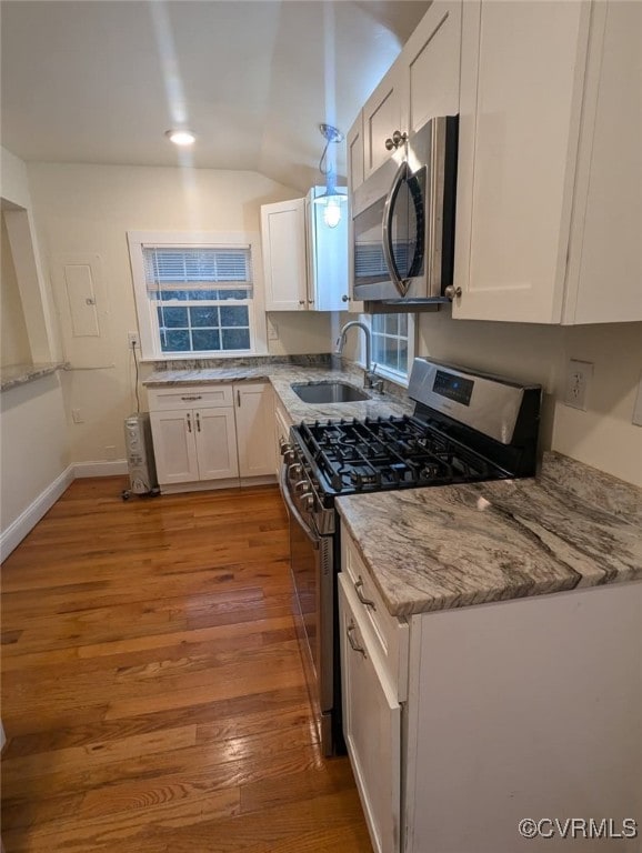 6080 Buckley Hall Rd, Mathews, VA 23035 - kitchen featuring a sink, light wood-style floors, white cabinetry, stainless steel appliances, and light stone counters