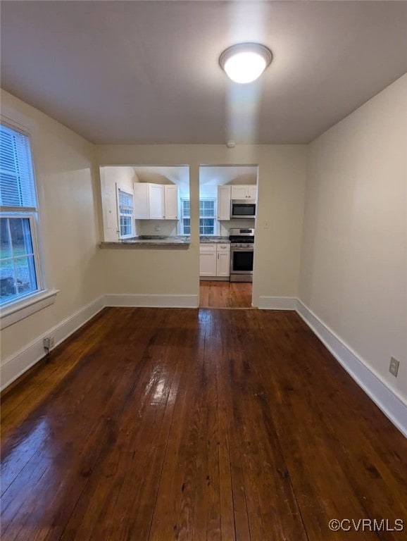 6080 Buckley Hall Rd, Mathews, VA 23035 - unfurnished living room featuring dark wood-type flooring and baseboards