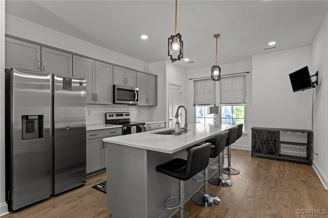 7217 Leire Ln, Chesterfield, VA 23832 - kitchen with stainless steel appliances, a sink, gray cabinetry, light countertops, and a breakfast bar